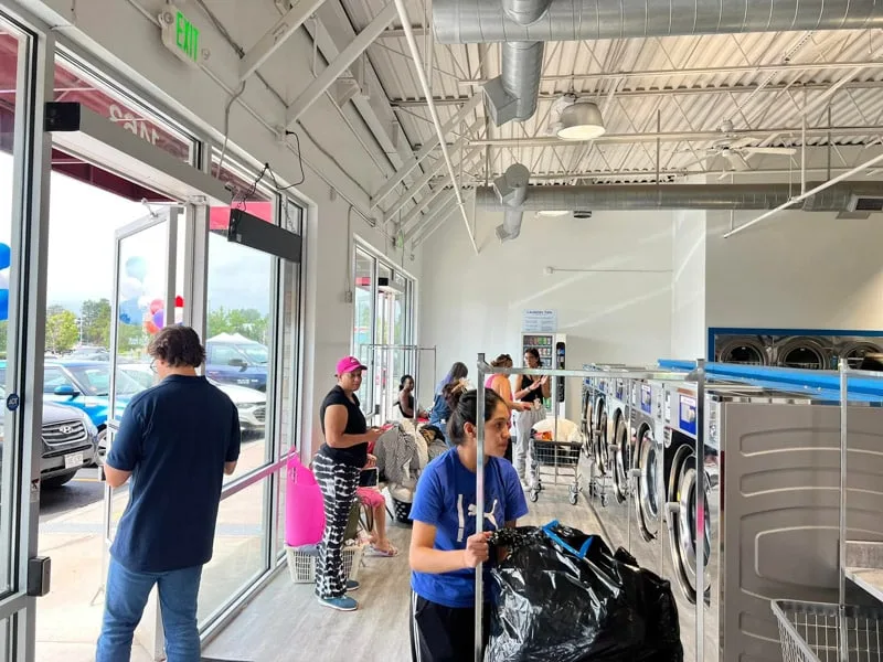 Clean interior of Sandy Creek Laundromat with customers doing laundry